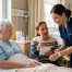 Nurse checks an elderly patient's wristband as her daughter shares a medicine list, a simple step in hospital patient safety